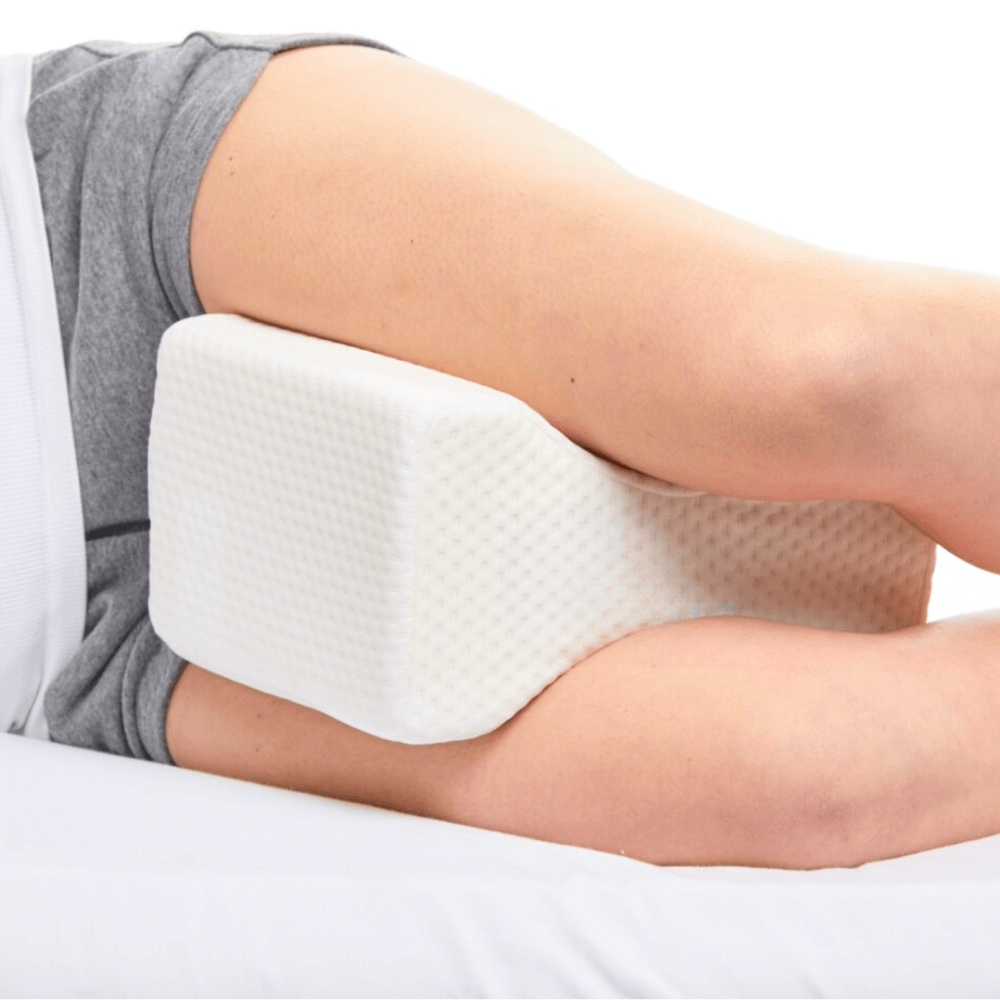 Leg resting on a white foam pillow.
