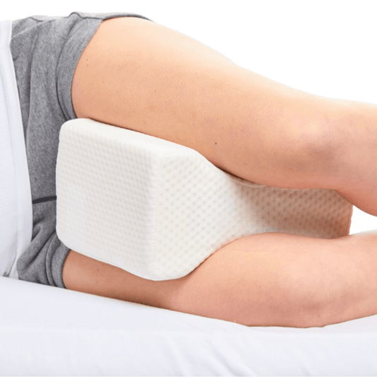 Leg resting on a white foam pillow.