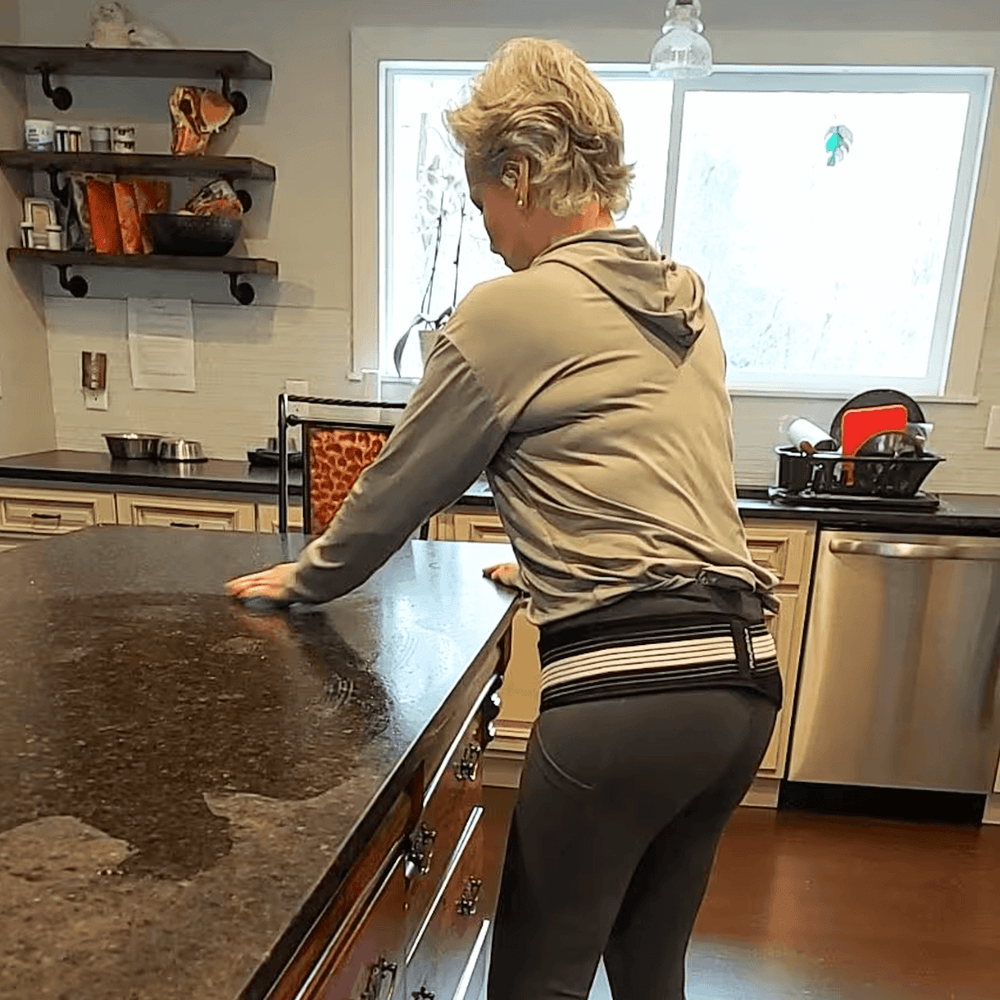 Woman in kitchen leaning on counter.