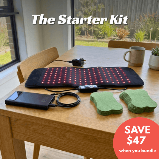 Starter kit with a black mat with red lights, power adapter, and green pads on a wooden table.